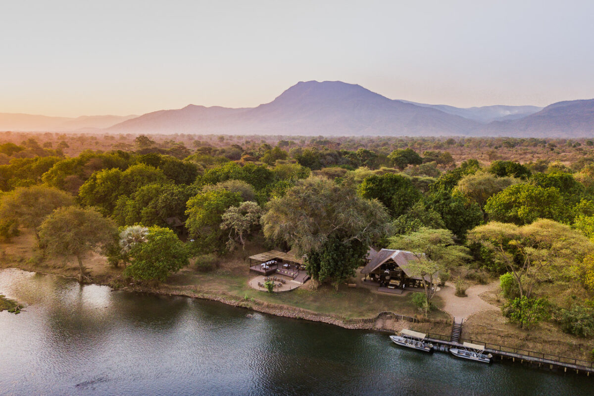Camp in Sambia am Fluss mit bergen im Hintergrund
